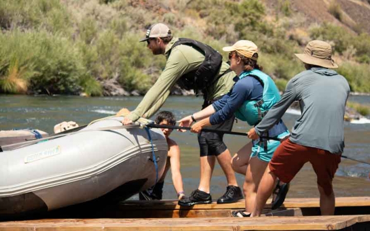a group of students pull a raft onto a trailer during a gap year semester with outward bound